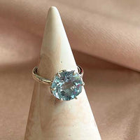 Flore - zilveren flowercup ring blauwe topaas