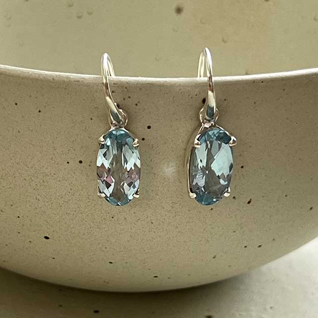 zilveren oorbellen met ovale blauwe topaas edelstenen